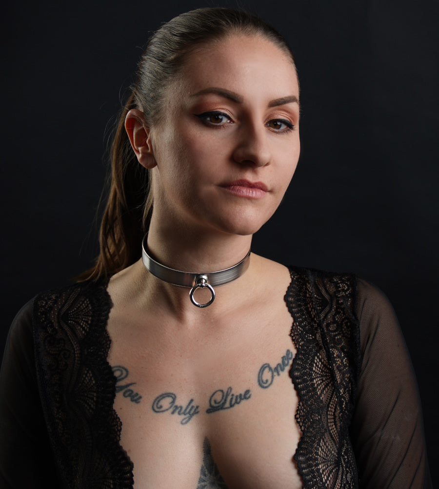Eine BDSM Sub trägt ein schlichtes Halsband aus Stahl, ergonomisch geformt und als Massanfertigung gearbeitet.